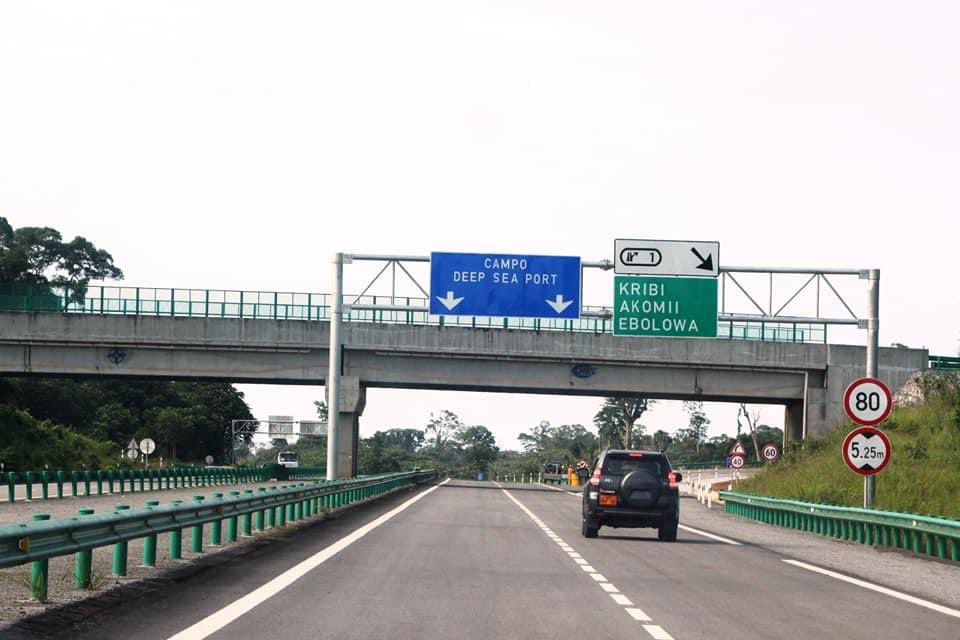 Modern Road Infrastructure in Cameroon - Group Victor A newly constructed asphalt road with streetlights and pedestrian walkways in Cameroon, surrounded by green vegetation and blue sky.